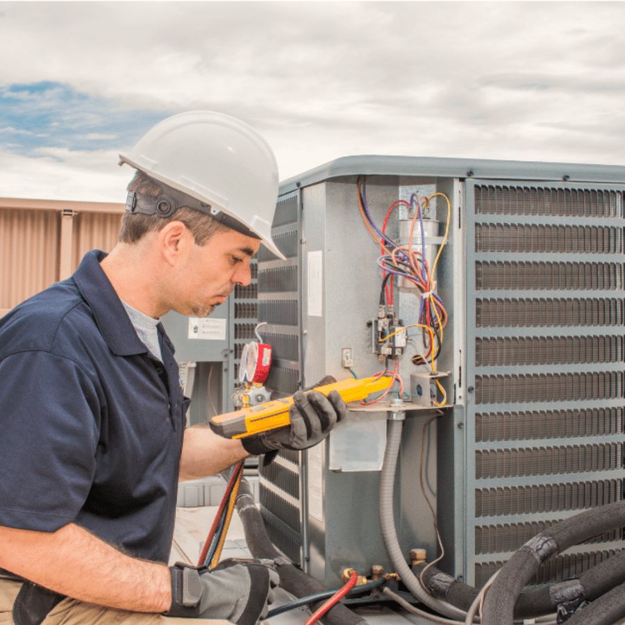 Oshawa Heating & Cooling HVAC technician servicing a system